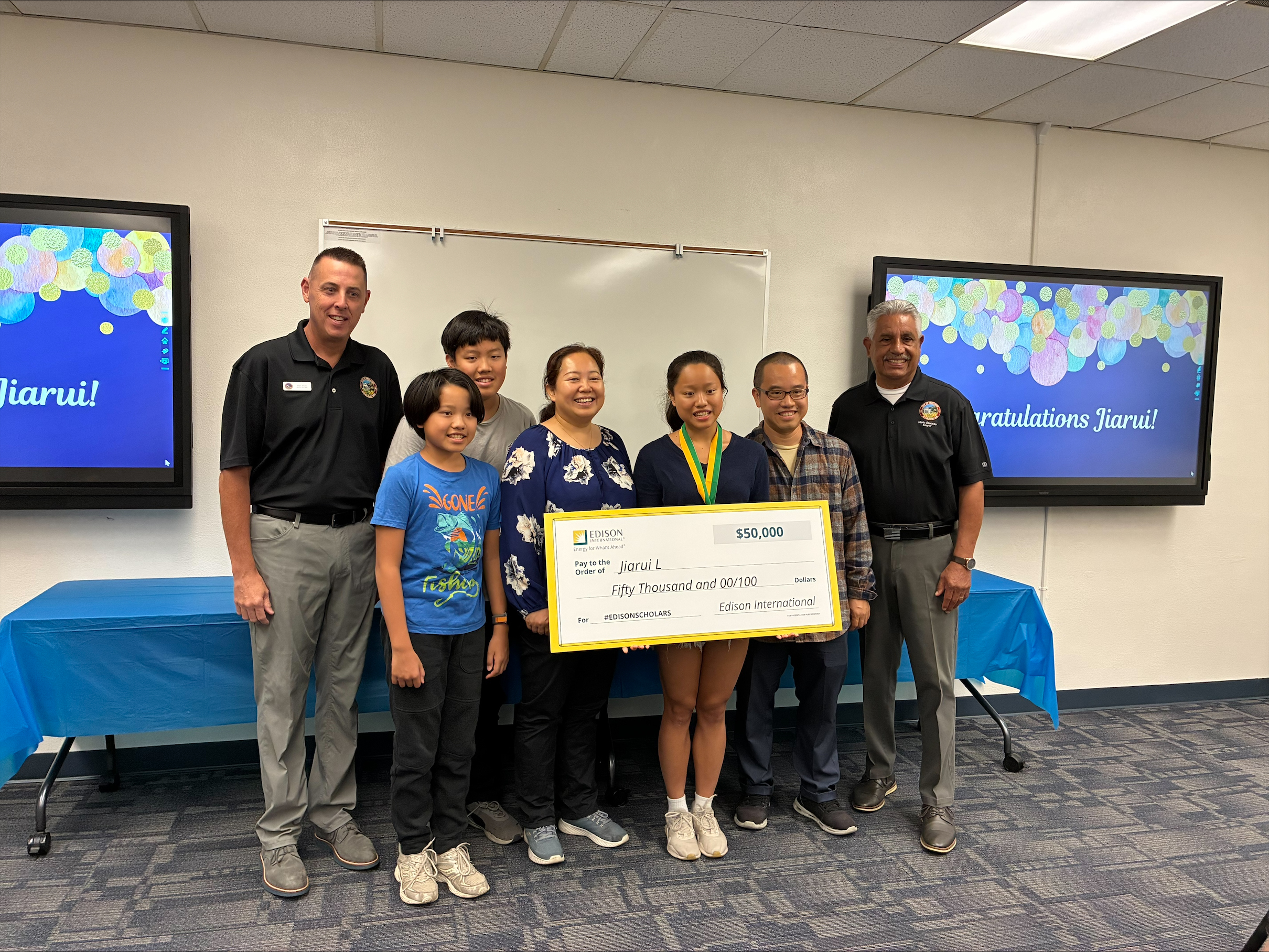 Family and city officials celebrate Jiarui's accomplishment.