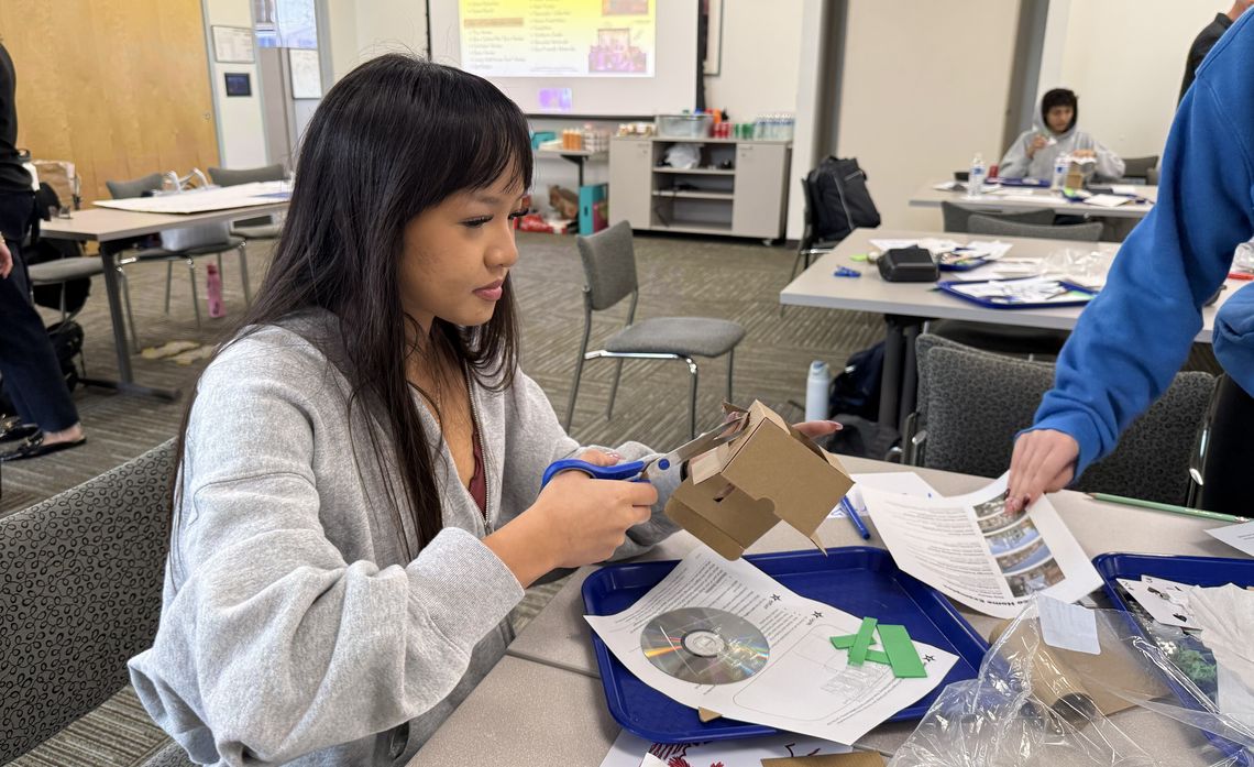Phoebe Morris, a student at Huntington Beach High School, works to build a miniature eco home with recycled material.    