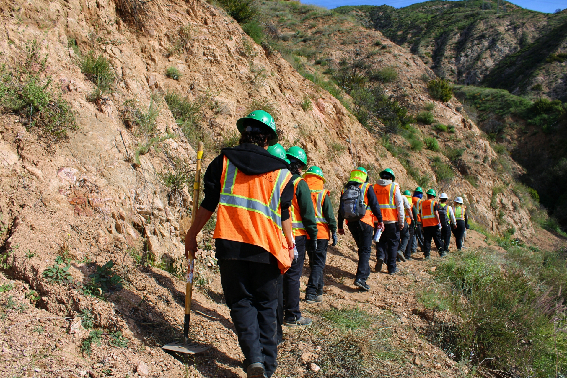 Members of the LA Conservation Corps hike into the Altadena Crest Trail to support wildfire recovery efforts.