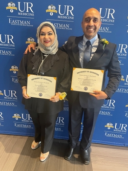 Mohammed and Furqan holding their certificates at graduation. 