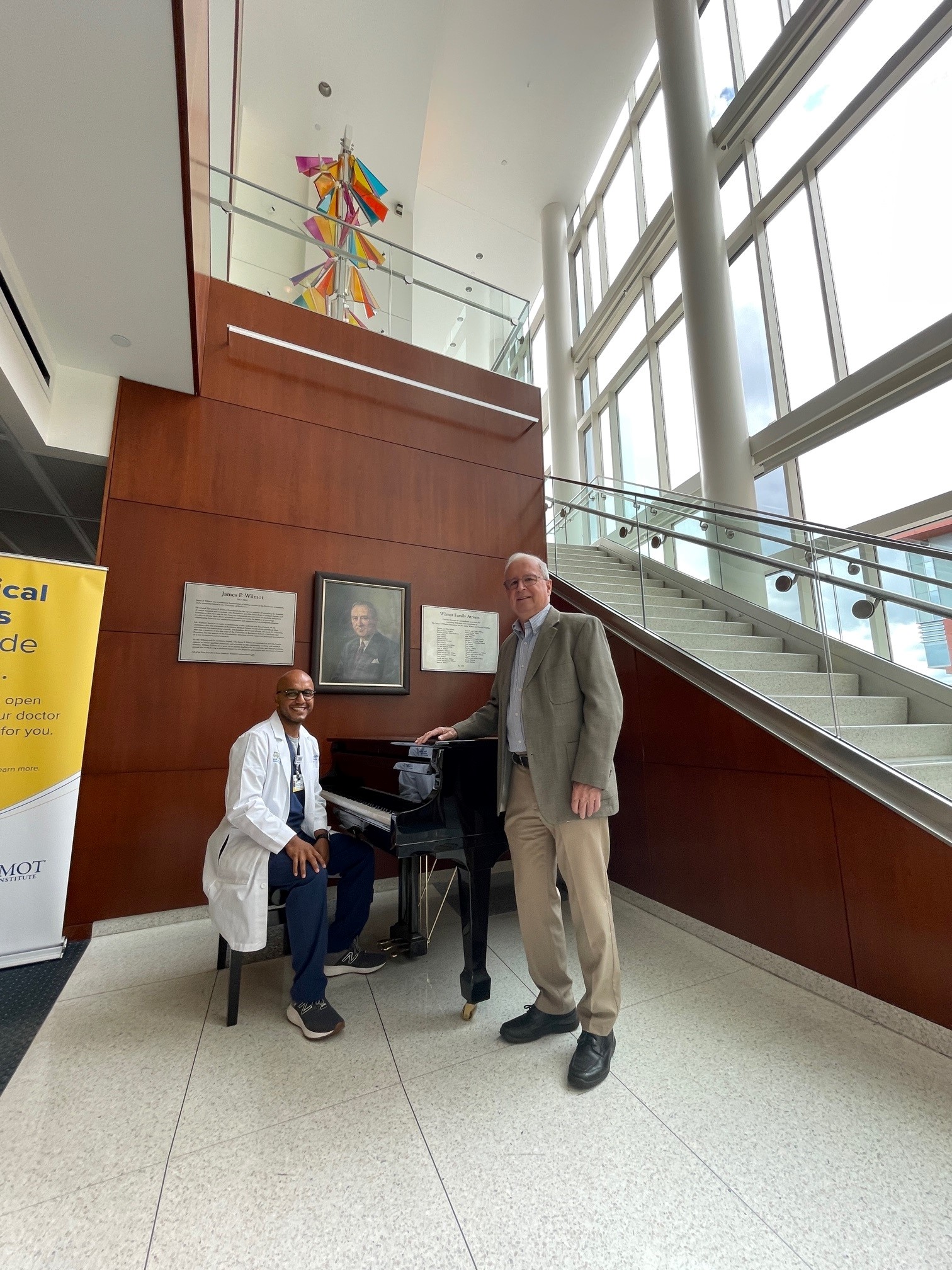 Dr. Mendez sitting at the piano and Mr. Bowman standing nearby