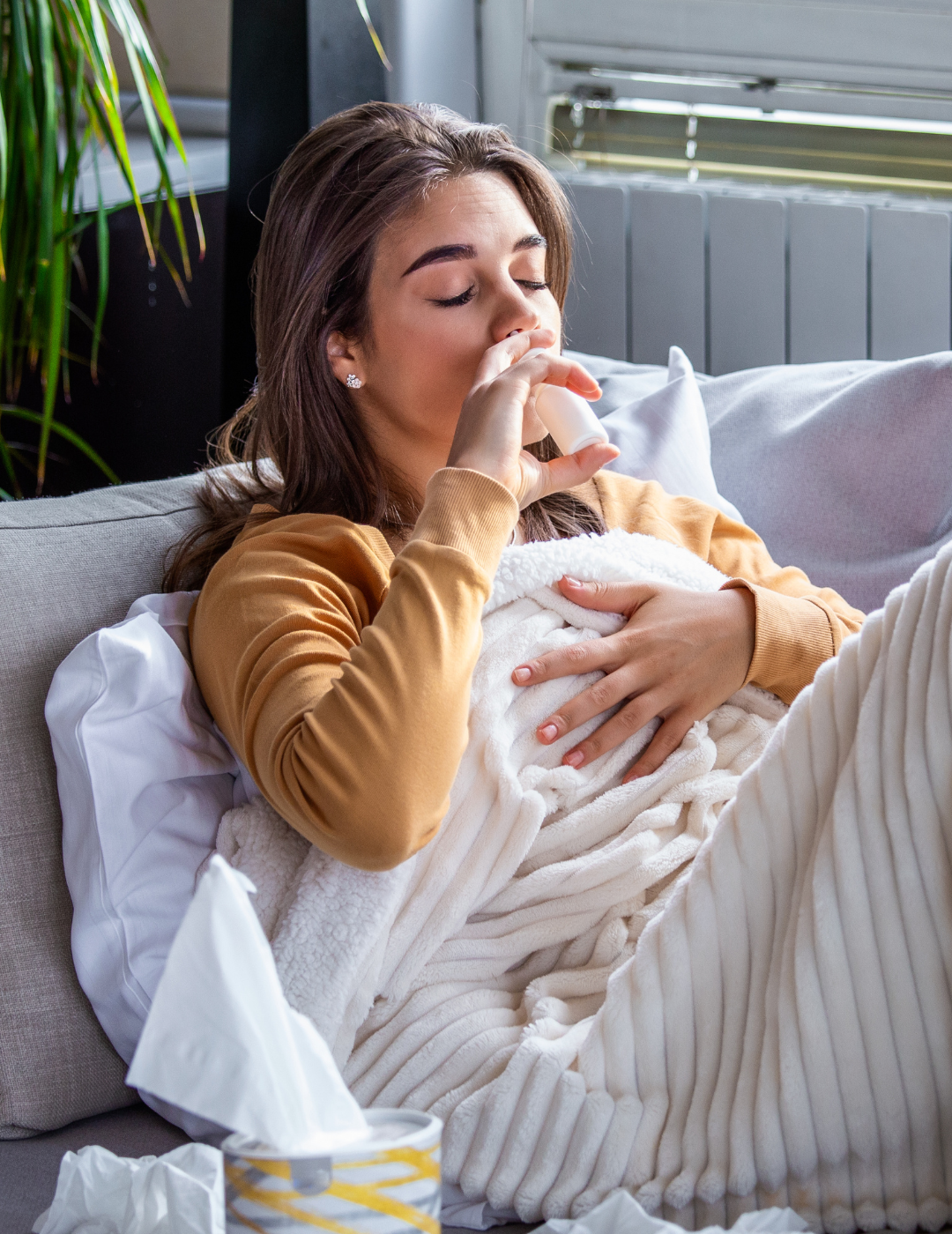 sick woman with head cold uses nasal spray