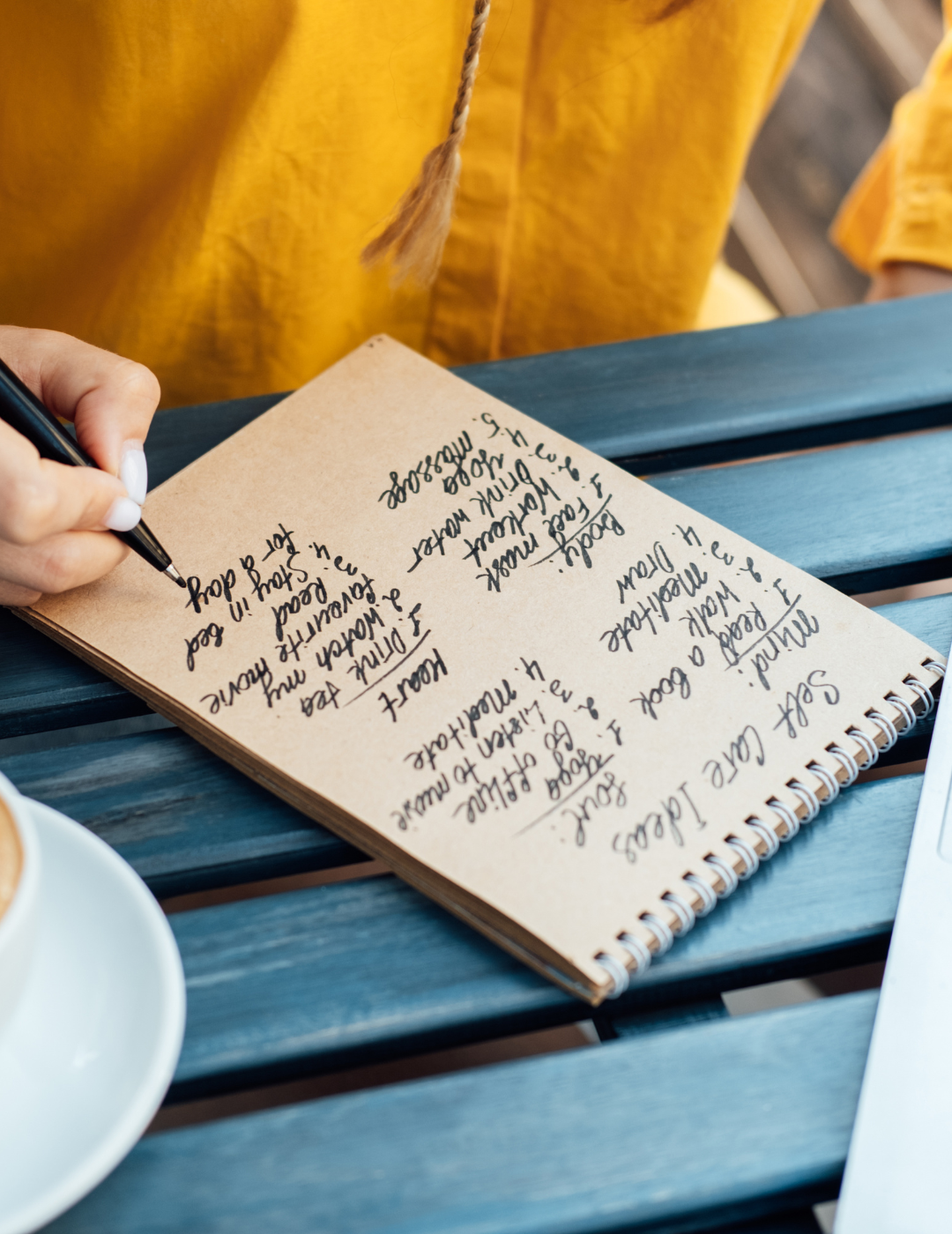 Person writing on a journal page.