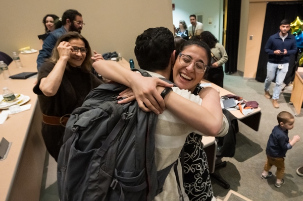Carley Haft (Oregon) gets a hug from friend Arman Niknafs as mom Marvin Mani watches. // University of Rochester School of Medicine and Dentistry students find out where their residencies will be on Match Day at the URMC March 15, 2024. // photo by J. Adam Fenster / University of Rochester