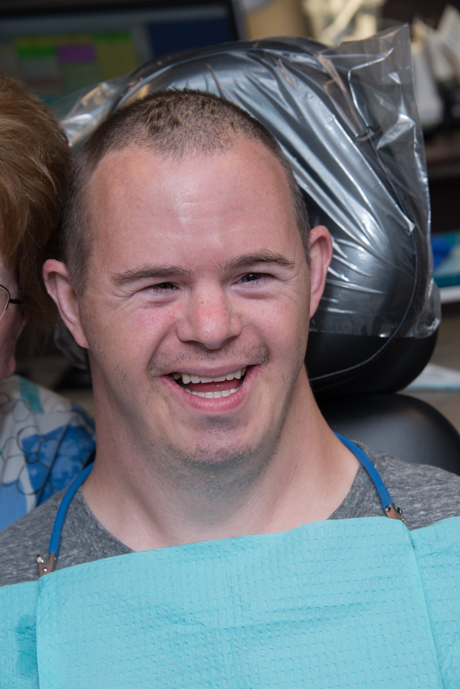 man with IDD smiling in dental chair