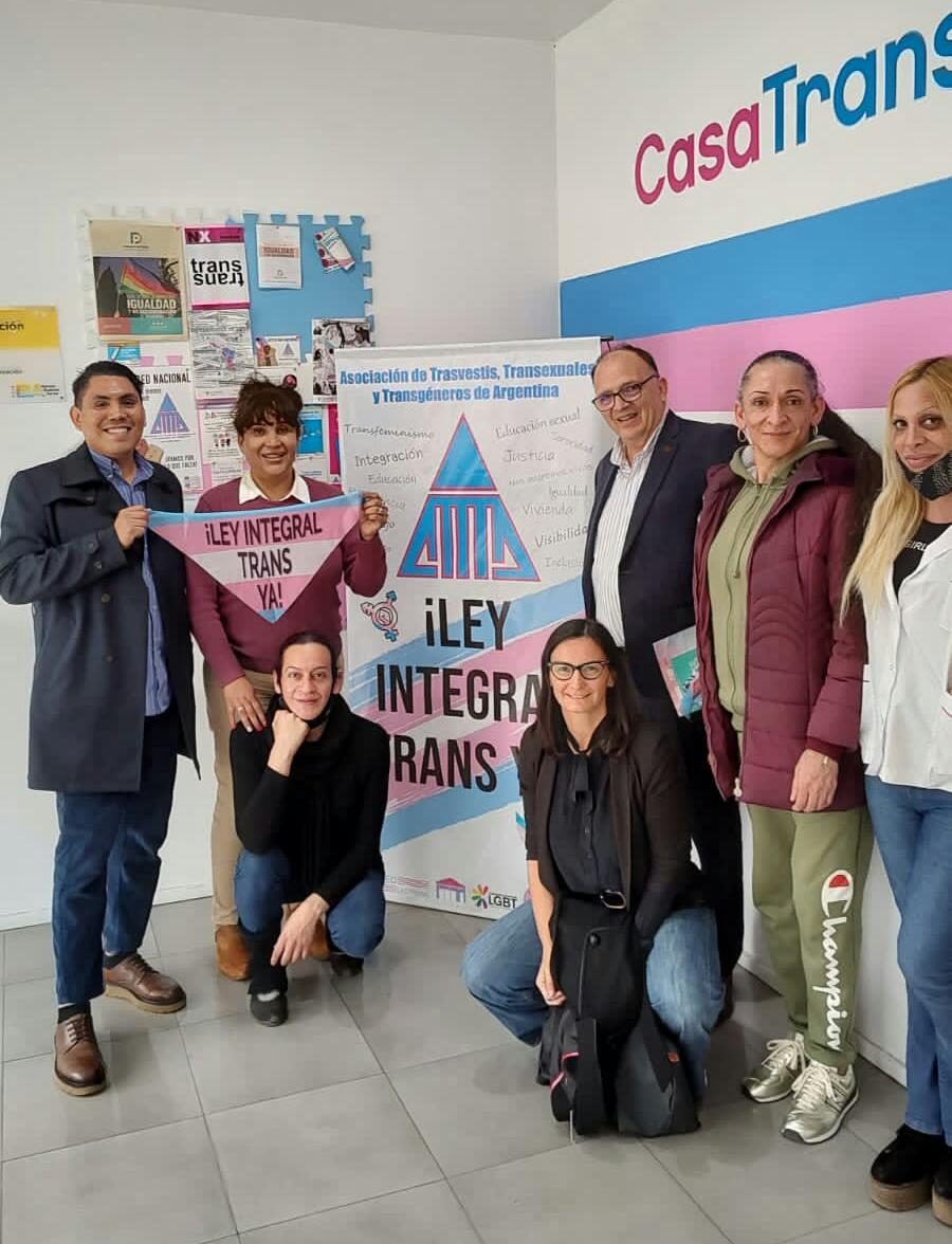 Group of people pose around signs to support Dr. Cartujano-Barrera's research in Argentina.