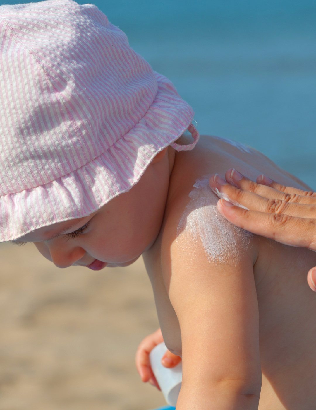Infant in a sun hat with sunscreen