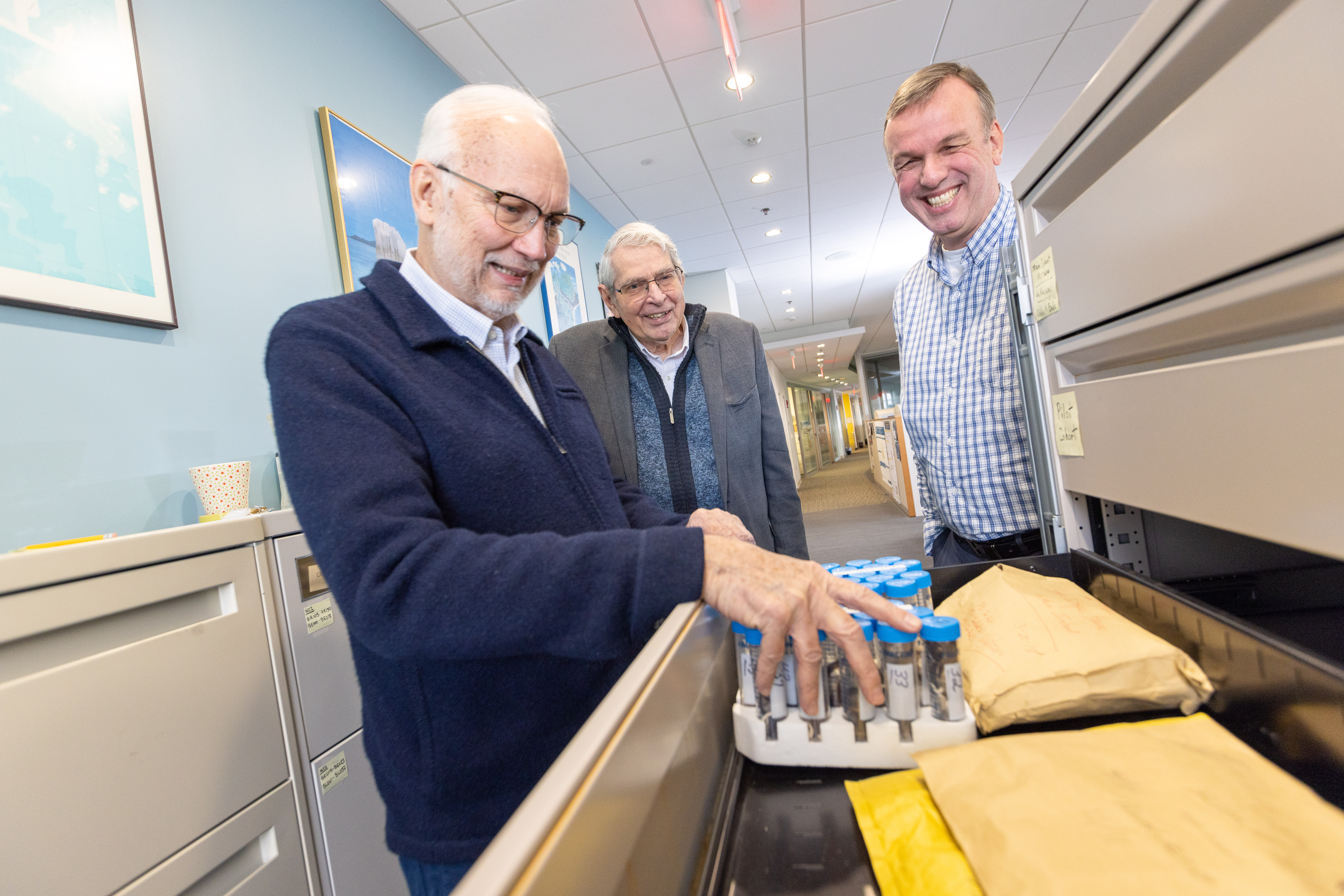 Gene Watson, DDS, PhD (left), looks through hair samples from participants in the Seychelles Child Development Study with Gary Myers, MD, (center), and Edwin van Wijngaarden, PhD. Mercury is known to deposit in hair, making it a robust resource for researchers studying mercury exposure.