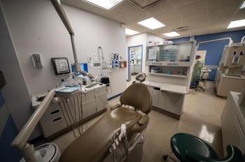 a turquoise chair sits next to a dark tan dental chair