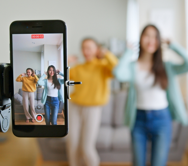 two young women filming themselves dancing