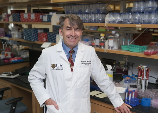 David McConkey stands next to a research bench in a laboratory at Wilmot Cancer Center.