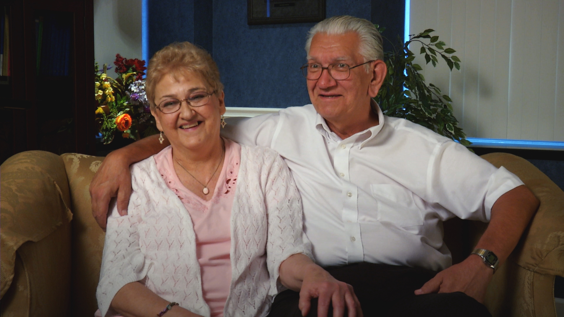 Couple sits together on couch