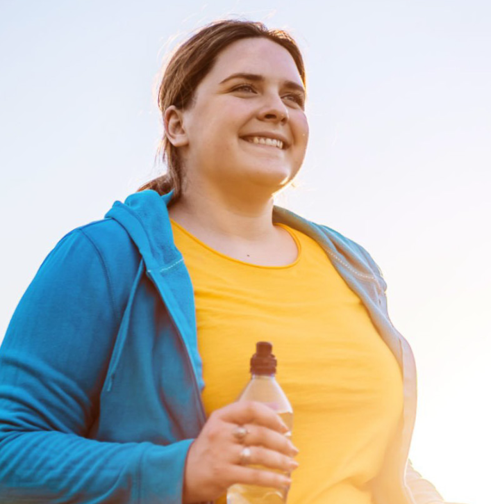 woman holding water bottle and exercising