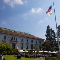 A photo of people sitting on a campus lawn in front of California Hall