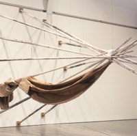 artwork in a gallery: twelve wooden tepee poles painted white, steel cable, charcoal, rope, digital print on linen