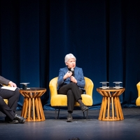 Three people seated on a stage holding microphones and speaking to an audience about the importance and challenges of protecting free speech.