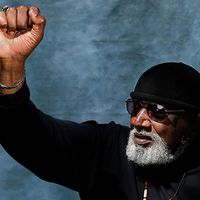 harry edwards holds his fist in the air to express solidarity and power