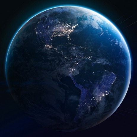 The Earth viewed from space at night with glowing city lights outlining continents.