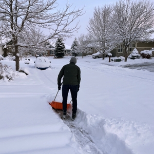 Man clearing snow on sidewalk