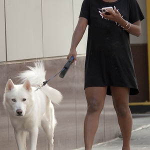 Woman with phone walking dog