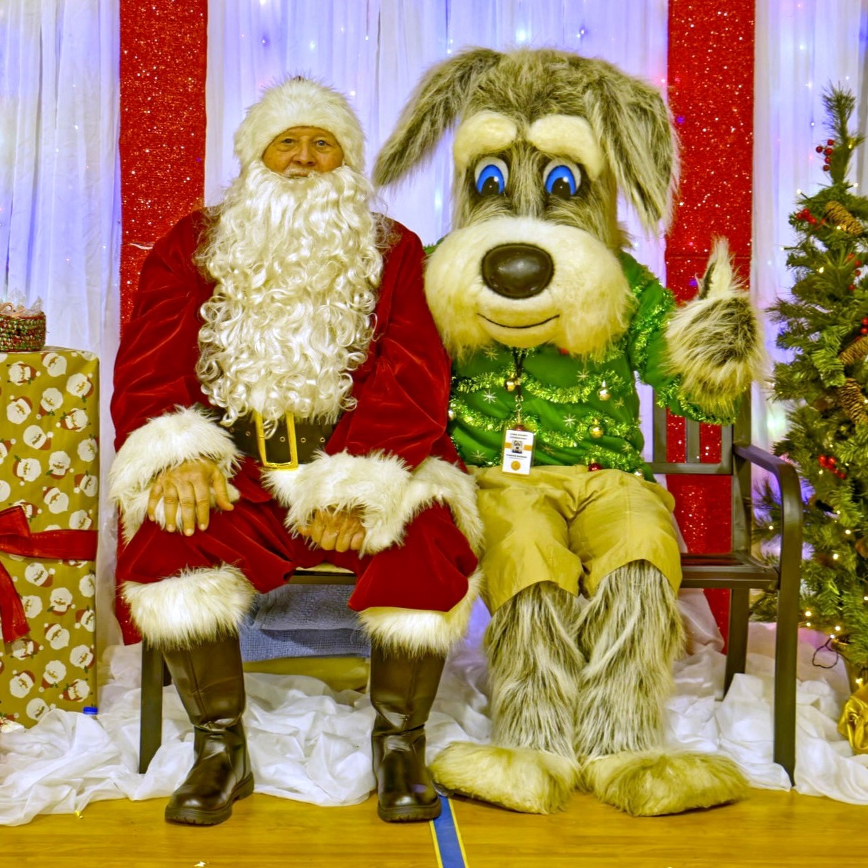 man in santa claus costume poses with parker the dog mascot 