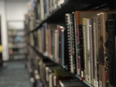 photograph looking down a library shelf full of books