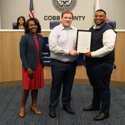 Whataburger representatives pose and receive proclamation given by chairwoman cupid