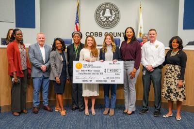 group poses with giant check for make-a-wish georgia