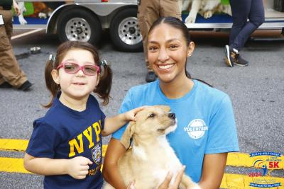 Animal services volunteer poses with child and a dog
