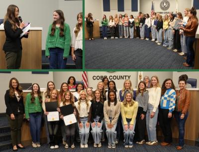 Commissioner Gambrill presents certificates to team, posing at meeting