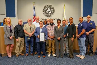 Staff posing in receipt of Building Safety Month Proclamation