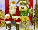 man in santa claus costume poses with parker the dog mascot 