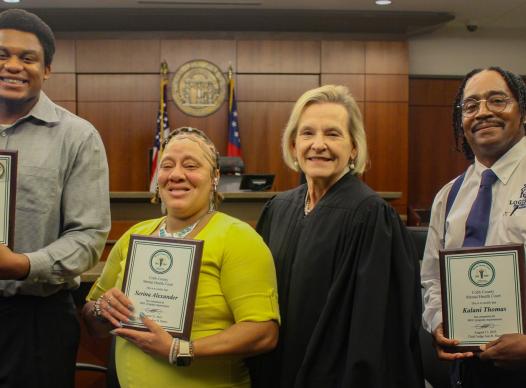 Three graduates from the Mental Health Court with Judge Ann Harris