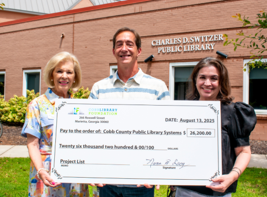 Members of the Cobb Library Foundation stand with the Cobb Library Director with an oversized check