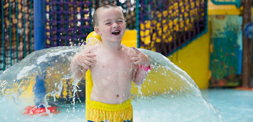 Child playing at waterpark in fountains