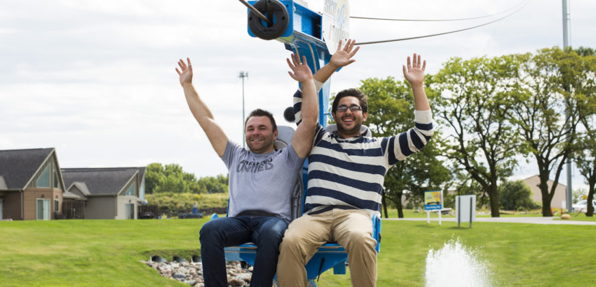 Two men going down a zipline together