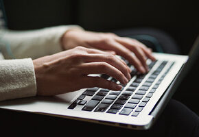 hands typing on keyboard of computer