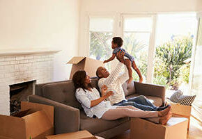Mother and father holding child in nearly moved into home