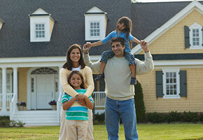 Family standing in front of house