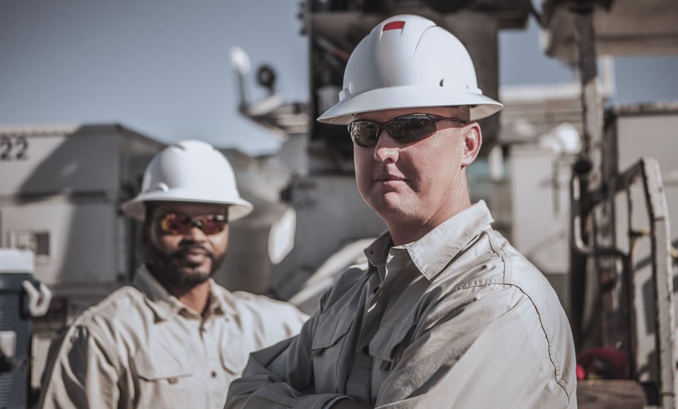 Image features two rural electric cooperative workers wearing hard hats