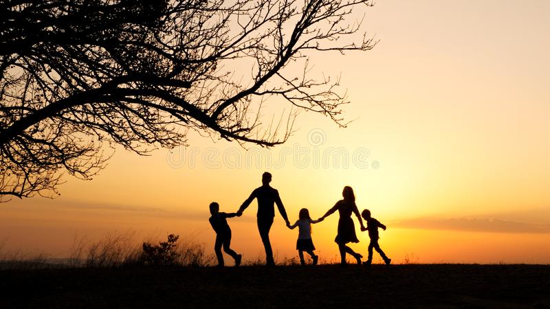 silhouettes-happy-family-walking-together-meadow-sunset-holding-hands-near-big-tree-143283649.jpg