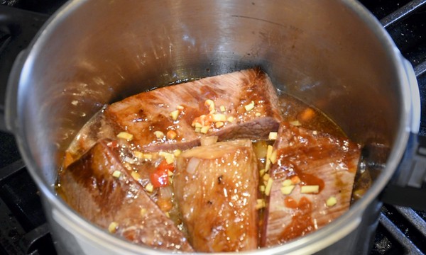 Pressure cooker brisket ingredients being added