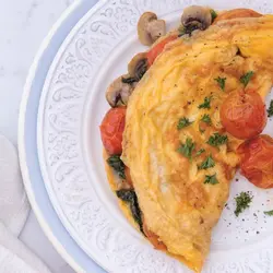 Omelette mei spinaazje, cherry tomaten en paddestoelen