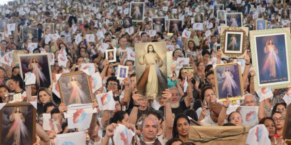 Pessoas na Canção Nova, casa da misericórdia, segurando o quadro de Jesus misericordioso.