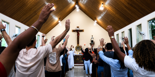 Pessoas rezando na capela da Comunidade Canção Nova. 