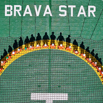 Equipe de trabalhadores em uniforme de segurança, posicionada de forma a formar um arco em plataforma offshore, com o nome 'Brava Star' ao fundo, destacando o trabalho colaborativo e seguro.