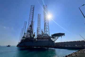 Offshore drilling platform 'Admarine' in port, with drilling structure prominent under sunlight.