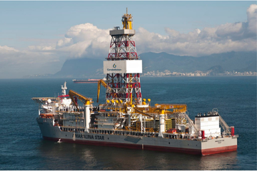 Offshore drilling platform 'Maralina Star' in operation at sea, with a view of the city in the background and drilling equipment in focus.