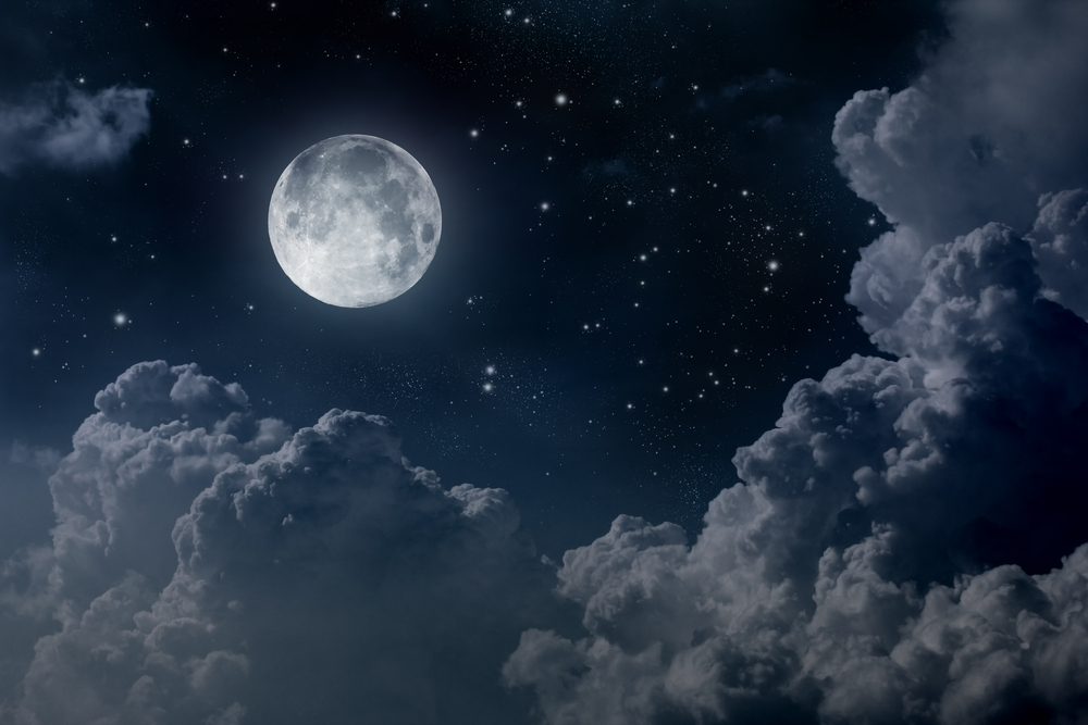 a full moon with stars and clouds in a night sky