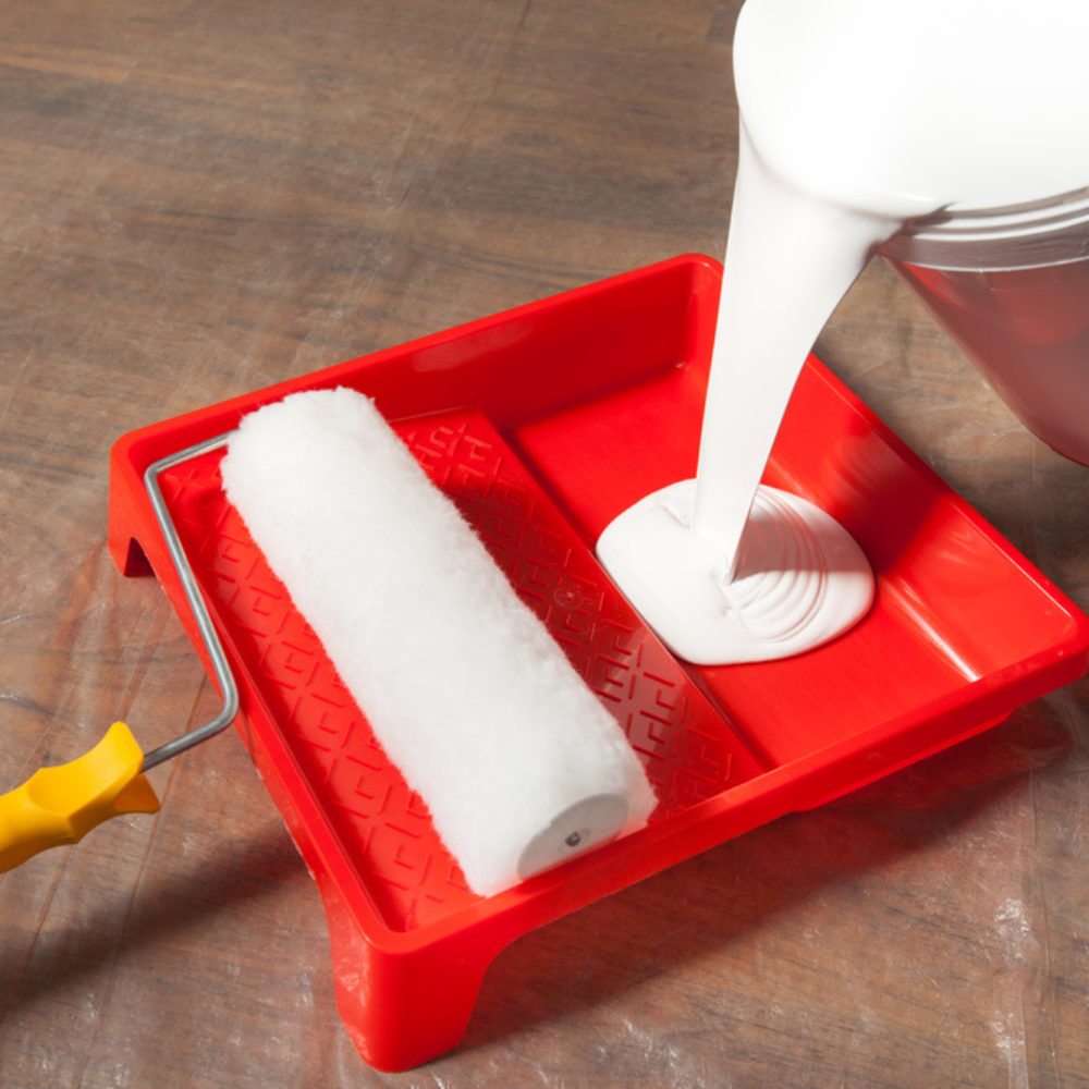 paint pouring from a bucket into a paint tray.